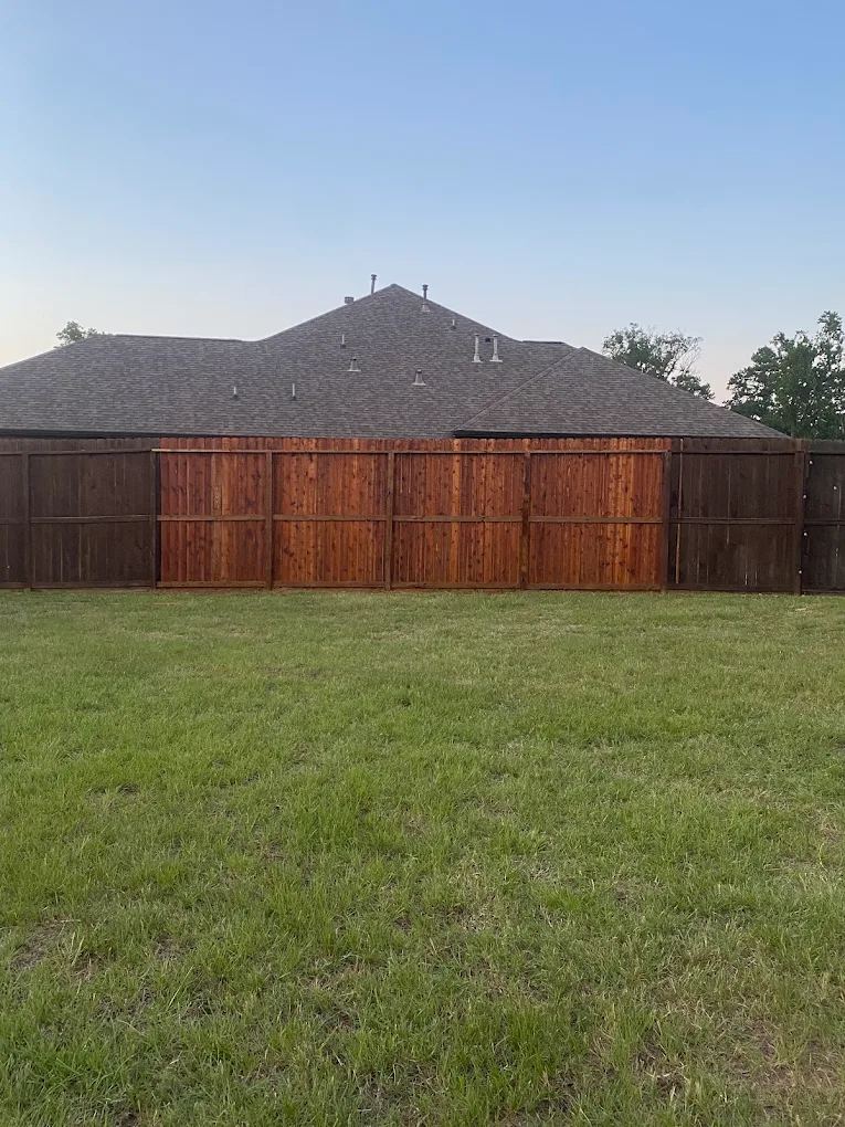 Replaced and freshly stained fence panels blending into an existing privacy fence